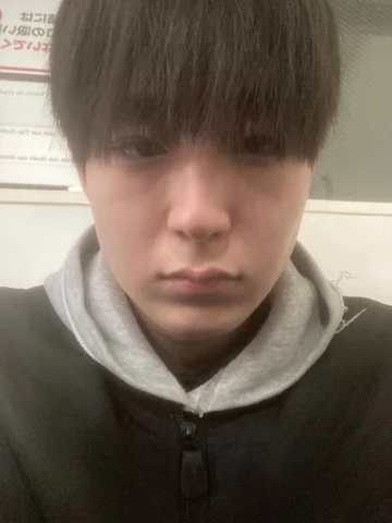 フード付きの服を着た人物の自撮り写真